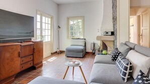 A living room with a TV, sofa, and wooden cabinet.