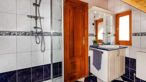 Ein Badezimmer mit Dusche, Waschbecken und Spiegel.
