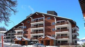 A multi-story hotel with wooden balconies and a snowy environment. - Valdor A 42 Sud by Interhome (Crans-Montana)
