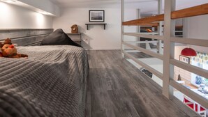 A modern bedroom with a bed, a nightstand, a clock, and a view of the outside through a glass balcony. - Apartment Rekowo by Interhome (Rekowo)