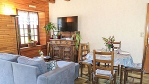Un salon confortable avec un canapé, une table à manger, des chaises et un téléviseur.