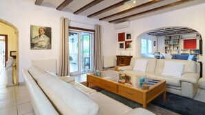 Een moderne woonkamer met een bank, salontafel en een boekenkast.