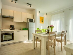 Enjoy meals in the kitchen with stainless steel appliances and a dining area with a table and chairs.
