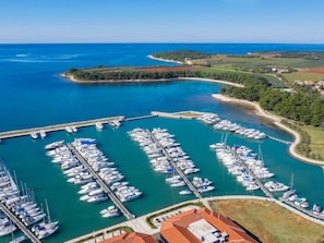 Stroll along the marina, surrounded by lush greenery and the clear blue sea.