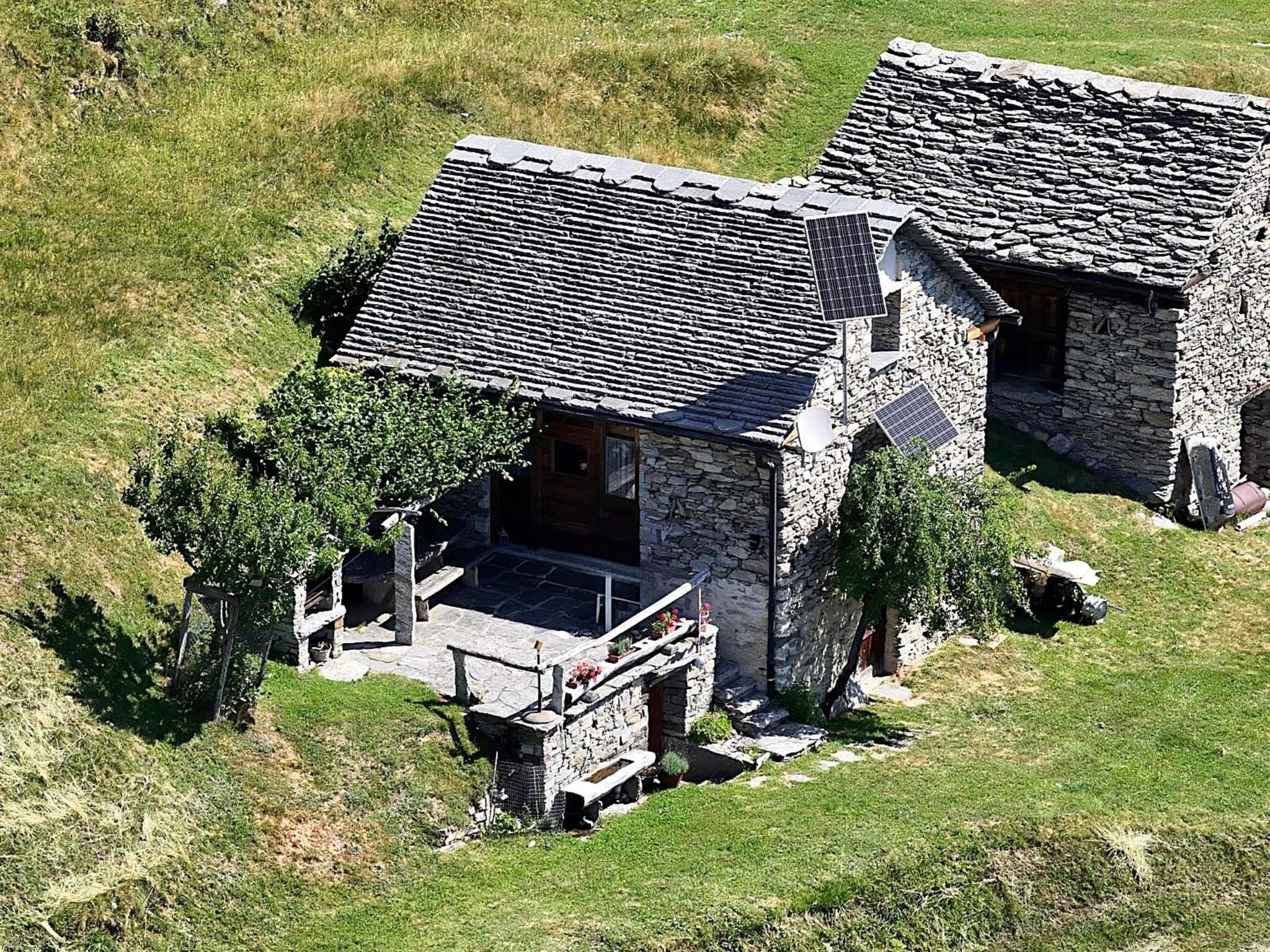 A stone house with a sloped roof and a small porch.