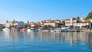 A coastal town with historic buildings, a marina with boats, and clear blue skies. - Mihaela 4 by Interhome (Rab/Rab)