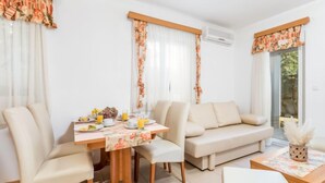 A modern living room with a dining table, two sofas, and a coffee table. - Mihaela 4 by Interhome (Rab/Rab)