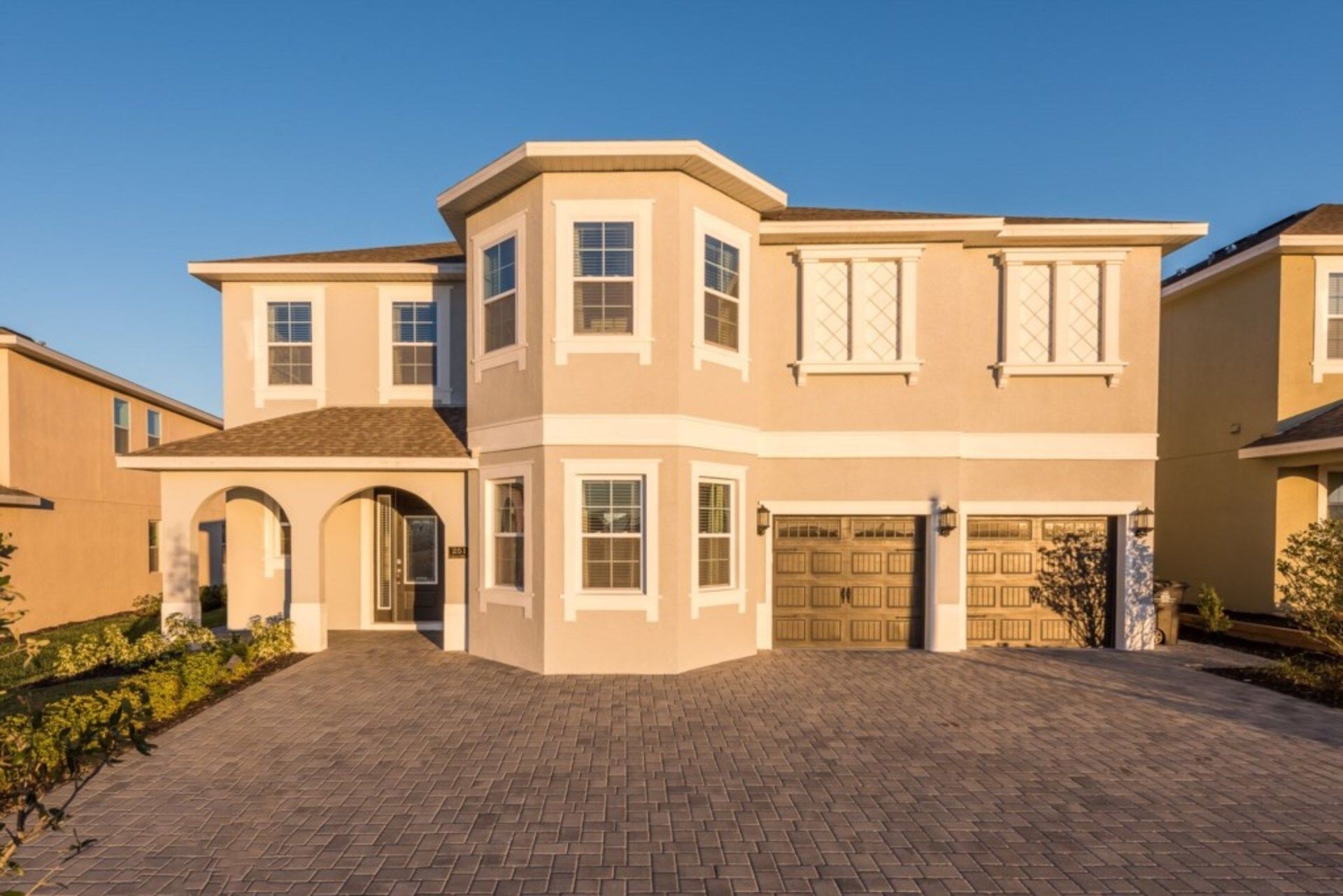 A two-story house with a garage, a driveway, and a landscaped front yard.