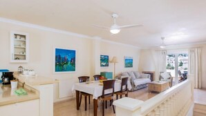 Un amplio espacio de sala con una mesa de comedor, sofás y un balcón con barandilla.