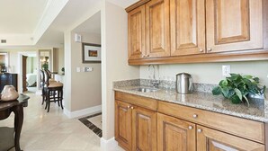 A kitchen with wooden cabinets, granite countertops, and a sink. - Private Villa 1980 (Kissimmee)