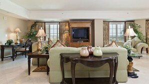 A spacious living room with a large sofa, a television, and decorative vases on a coffee table. - Private Villa 1980 (Kissimmee)
