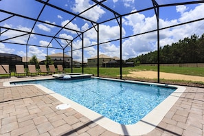 A swimming pool with a clear view of the sky and surrounding houses. - Villa in Champions Gate 1134 (Davenport)
