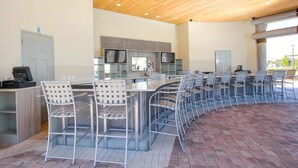 Un vaste espace extérieur doté d’un long bar et de nombreux espaces de détente.