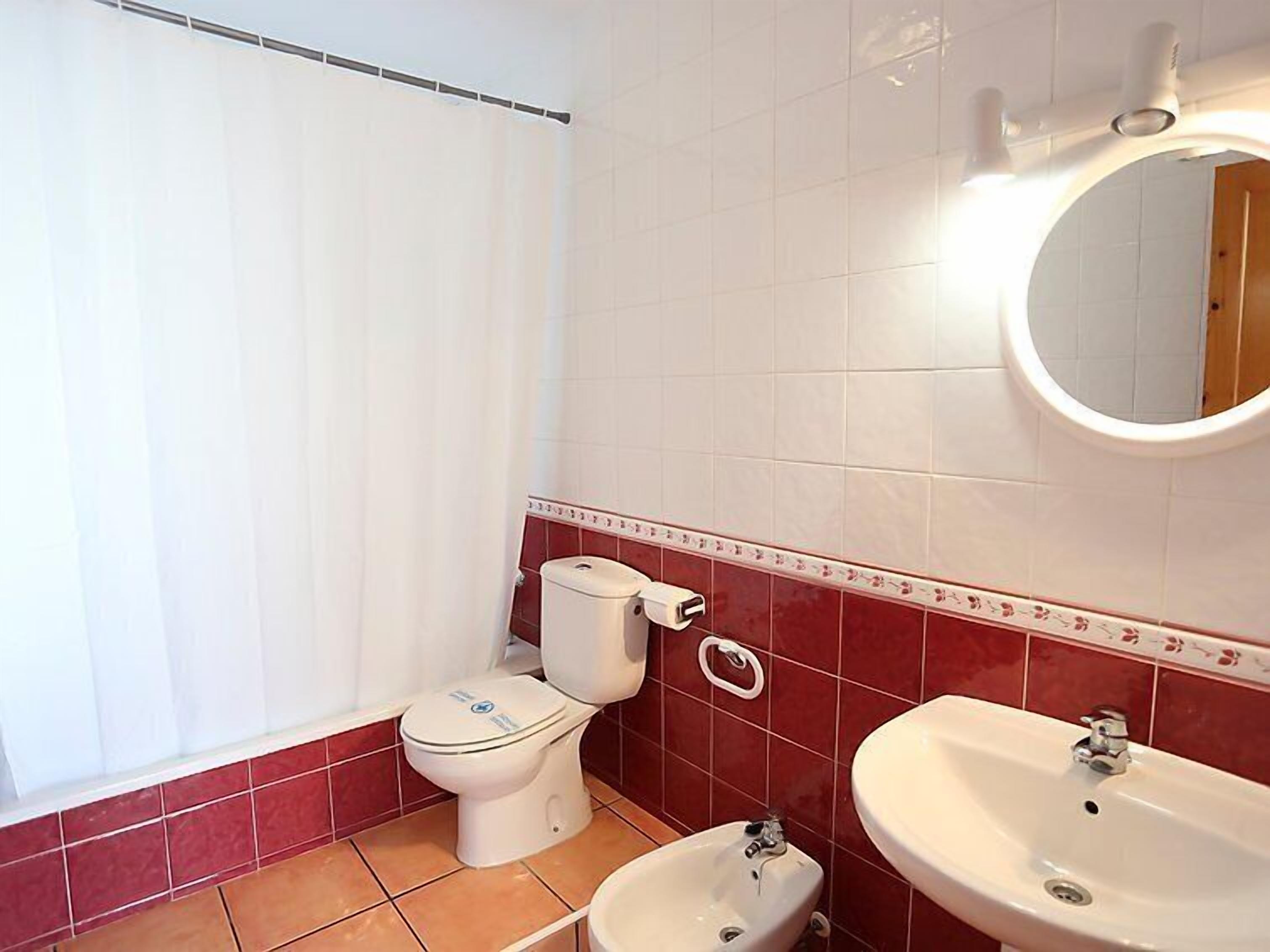 Ein Badezimmer mit Toilette, Bidet und zwei Waschbecken.