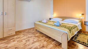 A bedroom with a bed, a wardrobe, and an air conditioning unit. - Apartment Marija by Interhome (Lovran)