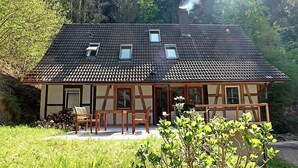 A chalet-style house with a sloped roof, wooden beams, and a chimney emitting smoke. - Leubach by Interhome (Wolfach)