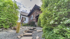 A traditional Japanese house with a stone pathway leading to the entrance, surrounded by lush greenery and a koi pond. - Vacation home Dworek by Interhome (Rychwald)