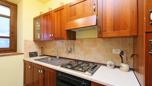 A kitchen with wooden cabinets, a gas stove, a sink, and a dishwasher.