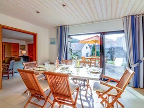 A spacious dining area with a large table set for six, surrounded by wooden chairs.