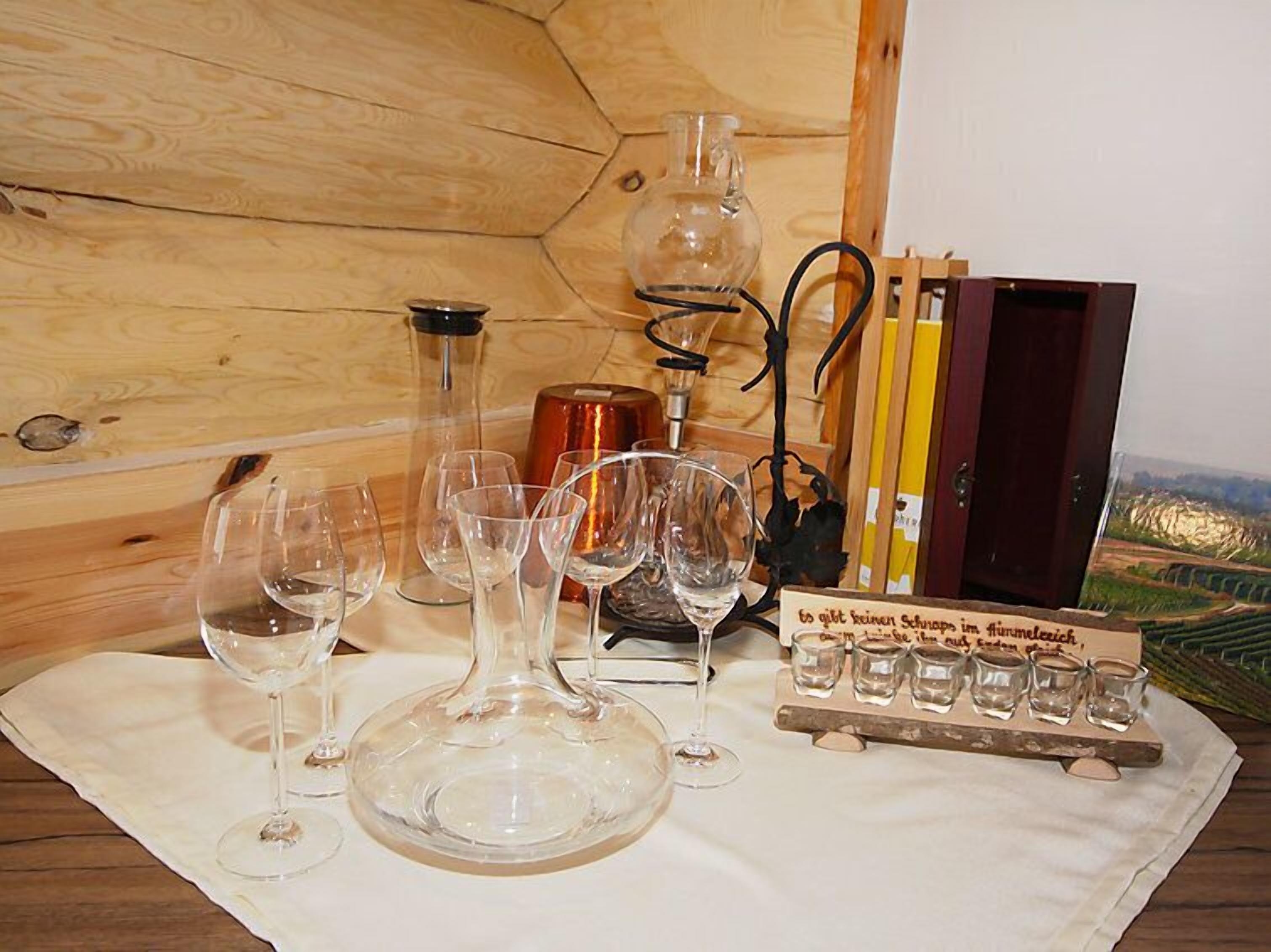 Un intérieur en bois agrémenté de verres à vin, d’une carafe, de verres à shooter et d’une enseigne avec du texte.