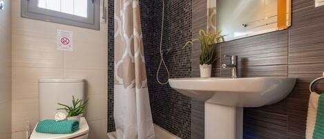 Une salle de bain moderne équipée d’une douche, de toilettes et d’un lavabo.