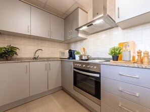 Een koelkast, een magnetron, een oven, kookgerei, borden en bestek