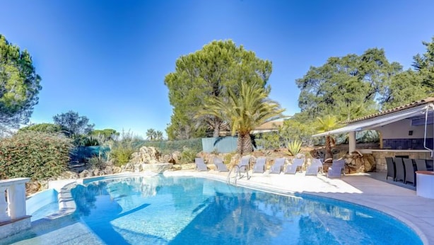 Une piscine avec des chaises longues et un espace patio.