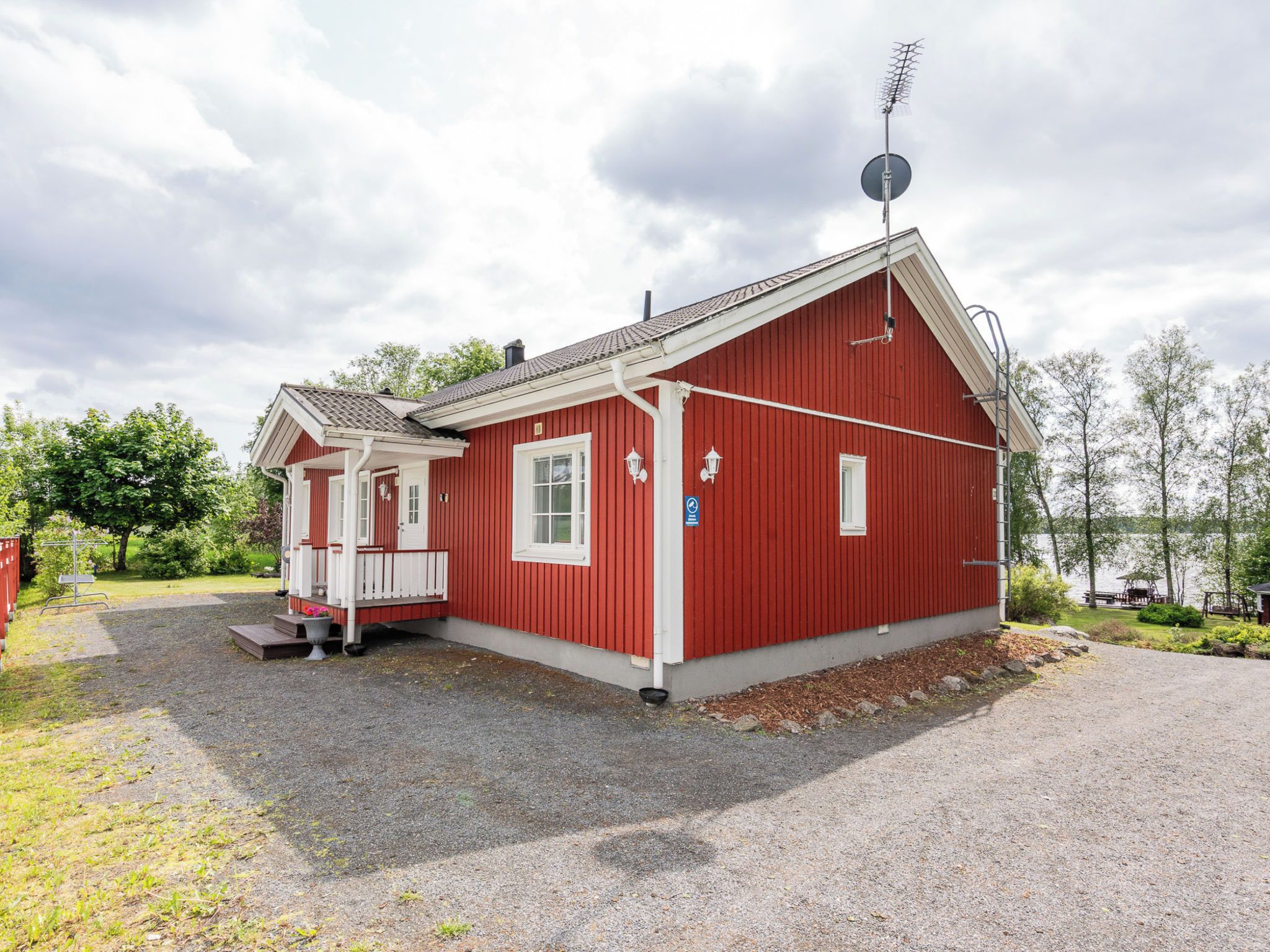 Ein rotes Gebäude mit überdachter Veranda und Satellitenschüssel.