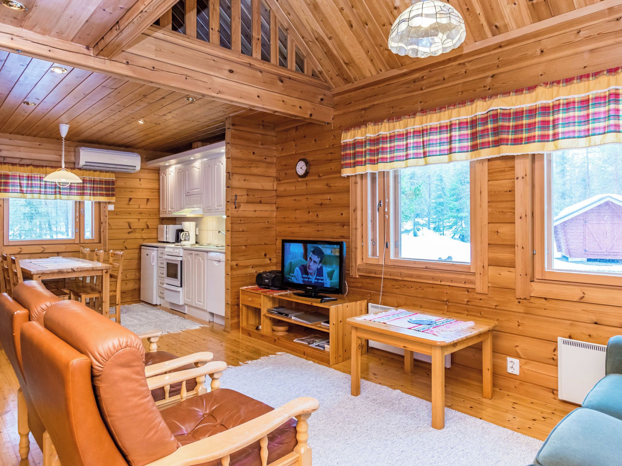 A cozy cabin interior with a dining area, kitchen, and seating space.