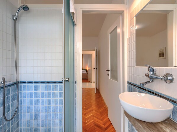 A bathroom with a shower, a sink, and a mirror. - Apartment Nika by Interhome (Umag)