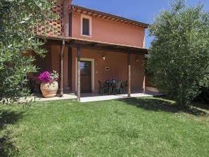 A two-story house with a covered patio and a small garden area. - Trilocale by Interhome (Orentano)