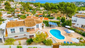 Una propiedad residencial con piscina, paneles solares y vista al mar.