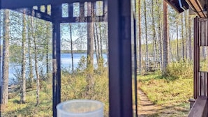 A wooden cabin with a view of a forest and a lake. - Pilkkaniemi by Interhome (Juuka)