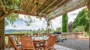 Une terrasse extérieure avec des meubles en bois et une vue sur la campagne.