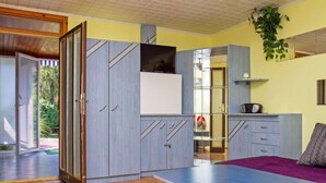 Eine moderne Küche mit integriertem Kühlschrank, einem Essbereich mit einer Bank und einer Glastür zum Außenbereich.