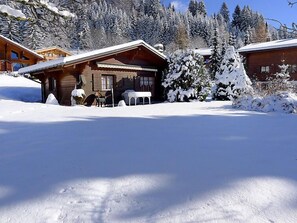 A wooden cabin with a snow-covered roof, surrounded by snow-covered trees and mountains. - Chalet Lorila by Interhome (Villars)