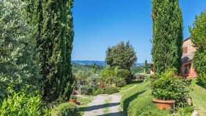 A garden path leading to a building surrounded by tall cypress trees and various shrubs. - Casa Mori by Interhome (Certaldo)