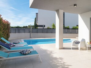 A modern outdoor pool area with lounge chairs and a covered seating area. - Villa Fasana by Interhome (Fažana)