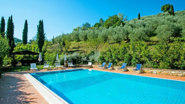 A swimming pool with lounge chairs and a pergola. - Il Gelsomino by Interhome (Montaione)