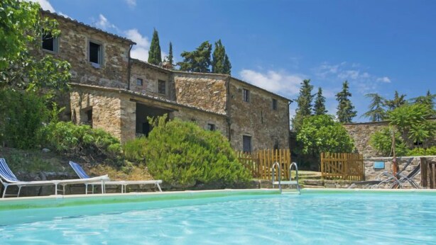 A stone building with a swimming pool, lounge chairs, and a wooden fence. - Le Bonatte by Interhome (Radda in Chianti)