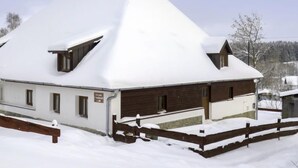 A snow-covered building with a steep roof, a wooden fence, and a clear sky. - Lenora I by Interhome (Lenora)