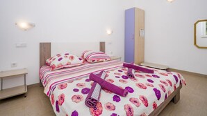 A bedroom with a bed, a nightstand, a dresser, and a wall-mounted mirror. - Apartment B&B by Interhome (Medulin/Ližnjan)