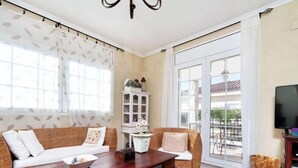 Un salon comprenant un canapé, un fauteuil, une table basse en bois et un meuble.