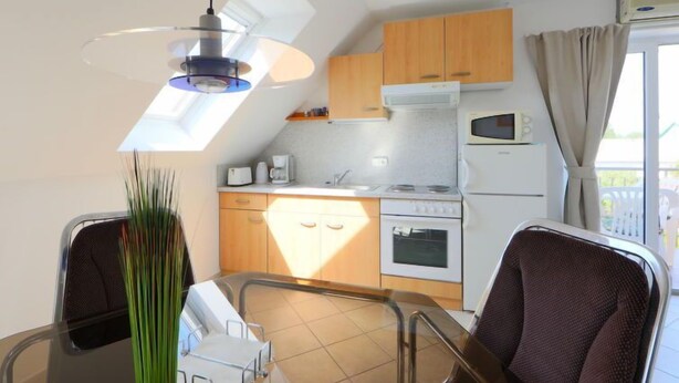 Una cucina compatta con zona pranzo, una lampada a soffitto e vista sull'esterno.