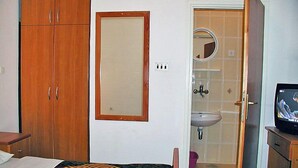 A hotel room with a bed, a wardrobe, a mirror, a sink, and a television. - Apartment Zdenko by Interhome (Ugljan/Kali)