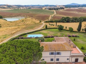 Une villa avec piscine, entourée d’un jardin luxuriant et offrant une vue sur des collines verdoyantes.