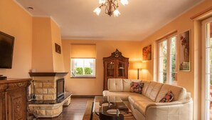 A living room with a fireplace, sofa, and a television.