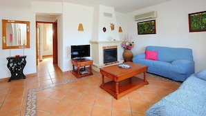 A living room with a television, a fireplace, a sofa, and a coffee table. - Vacation home Inma by Interhome (Pego)