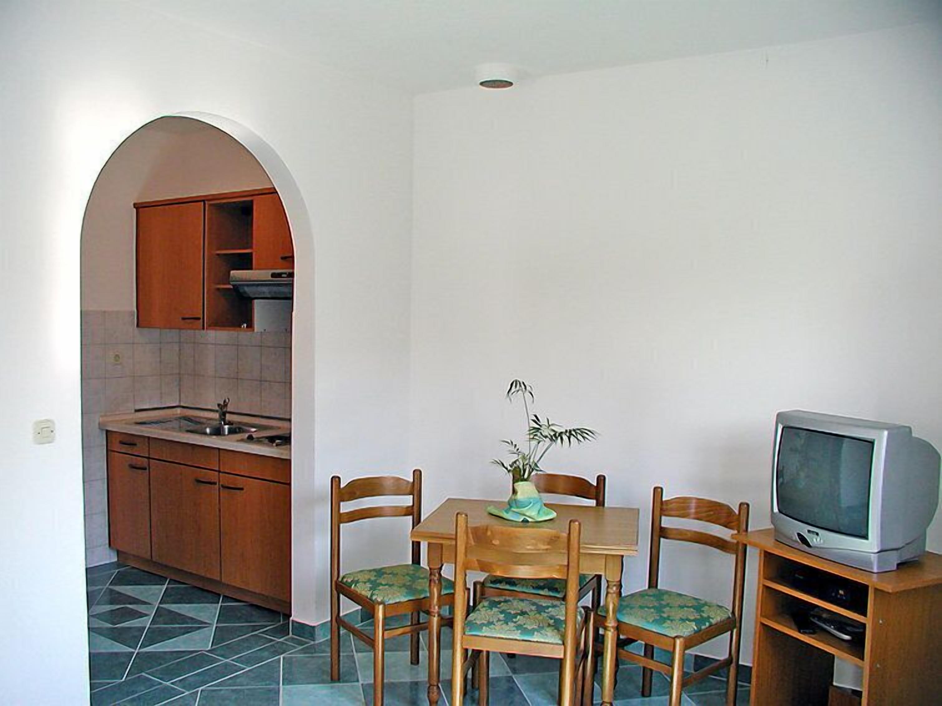 A compact kitchen with wooden cabinets and a tiled floor.
