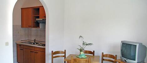 A compact kitchen with wooden cabinets and a tiled floor.